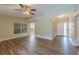 A living room featuring an open layout with wood-look laminate flooring, neutral colored walls, and a ceiling fan at 5201 Palisades Dr, Orlando, FL 32808