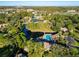 Community aerial view showcasing a pool, lake, and lush greenery at 6021 Windhover Dr # F11, Orlando, FL 32819