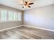Neutral bedroom with ceiling fan, wood-look floors and shuttered windows at 6021 Windhover Dr # F11, Orlando, FL 32819