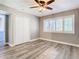 Bedroom boasts shuttered windows, ceiling fan, wood-look floors and closet at 6021 Windhover Dr # F11, Orlando, FL 32819