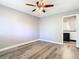 Bright bedroom with wood-look floors, ceiling fan, and attached bathroom at 6021 Windhover Dr # F11, Orlando, FL 32819
