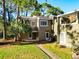 Inviting home exterior featuring a well-maintained lawn and beautiful trees providing shade at 6021 Windhover Dr # F11, Orlando, FL 32819