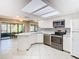 Sunlit kitchen featuring white cabinets, stainless appliances and granite countertops at 6021 Windhover Dr # F11, Orlando, FL 32819