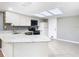 Bright kitchen features a skylight, granite counters, stainless appliances, and white cabinets at 6021 Windhover Dr # F11, Orlando, FL 32819