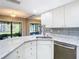 Kitchen with white cabinets, granite countertops and tile backsplash at 6021 Windhover Dr # F11, Orlando, FL 32819