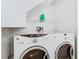 Close-up of laundry machines and shelf in the laundry area at 6021 Windhover Dr # F11, Orlando, FL 32819