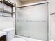 Bathroom view of frosted glass shower doors and a metal storage unit at 6021 Windhover Dr # F11, Orlando, FL 32819