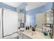 Clean bathroom with a white vanity, blue walls, and a shower, designed for functionality and style at 6037 Caymus Loop, Windermere, FL 34786