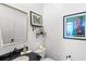 Charming powder room features a dark granite vanity, framed mirror, and fun Disney artwork at 6037 Caymus Loop, Windermere, FL 34786