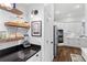 Open pantry area that features floating shelves, a modern light fixture, and black granite countertops at 6037 Caymus Loop, Windermere, FL 34786