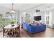 Living room with large windows, hardwood floors, a ceiling fan, and a comfortable blue sofa at 6037 Caymus Loop, Windermere, FL 34786