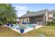 Backyard pool and patio area with a tropical landscaping, surrounded by lounge furniture, and potted plants at 6037 Caymus Loop, Windermere, FL 34786