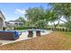 Backyard pool and patio area with a tropical landscaping, surrounded by lounge furniture, and potted plants at 6037 Caymus Loop, Windermere, FL 34786