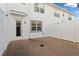 A brick-paved backyard with white fencing and a door to the townhome at 6165 Juneberry Way, Winter Garden, FL 34787
