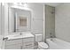 Well-lit bathroom with a large mirror, tiled shower, and modern fixtures and neutral coloring at 6165 Juneberry Way, Winter Garden, FL 34787
