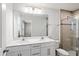 Bathroom with a double vanity, large mirror, and walk-in shower at 6165 Juneberry Way, Winter Garden, FL 34787