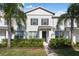 Charming two-story townhome featuring a well-manicured lawn with lush landscaping and classic shutters at 6165 Juneberry Way, Winter Garden, FL 34787