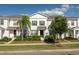 Inviting two-story townhome showcasing lush front yard landscaping with a sidewalk leading to the front door at 6165 Juneberry Way, Winter Garden, FL 34787