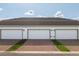 Spacious three-car garage with brick driveways and manicured lawn in front of each space at 6165 Juneberry Way, Winter Garden, FL 34787