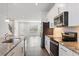 Modern kitchen showcasing stone counters, stainless steel appliances, and backsplash, open to the living area at 6165 Juneberry Way, Winter Garden, FL 34787