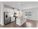 Modern kitchen with stainless steel appliances, granite countertops, island, and white cabinetry at 6165 Juneberry Way, Winter Garden, FL 34787