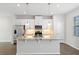 Bright kitchen features an island with stone countertops, stainless steel appliances, and modern pendant lighting at 6165 Juneberry Way, Winter Garden, FL 34787