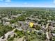 Broad aerial view shows the property within a neighborhood, surrounded by lush greenery and other homes at 675 S Cedar Ave, Orange City, FL 32763