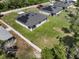An aerial view shows the home with solar panel, backyard, and neighboring houses at 675 S Cedar Ave, Orange City, FL 32763