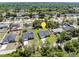 A wide aerial view shows a lovely neighborhood setting surrounded by lush forest and multiple residences at 675 S Cedar Ave, Orange City, FL 32763