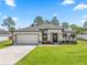 Beautiful single Gathering home featuring a manicured lawn, two car garage and freshly painted exterior at 675 S Cedar Ave, Orange City, FL 32763