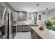 Modern kitchen features stainless steel appliances, gray cabinets, and a large center island with quartz countertops at 675 S Cedar Ave, Orange City, FL 32763