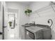 Clean laundry room with modern washer and dryer, storage shelving, and ample space at 675 S Cedar Ave, Orange City, FL 32763