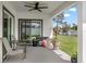 Covered patio with ceiling fan, outdoor seating, and view of the lush green backyard at 675 S Cedar Ave, Orange City, FL 32763