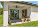 Covered patio with ceiling fan, outdoor seating, and view of the lush green backyard at 675 S Cedar Ave, Orange City, FL 32763