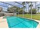 Relax in this fenced-in backyard pool with a screened enclosure and outdoor dining area at 730 Bloomingdale Dr, Davenport, FL 33897