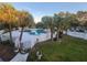 Outdoor swimming pool surrounded by a white picket fence and several mature palm trees at 7900 S Orange Blossom Trl # 2025, Orlando, FL 32809