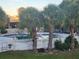A fenced community pool is surrounded by palm trees, lawn furniture, and a grassy area at 7900 S Orange Blossom Trl # 2025, Orlando, FL 32809