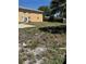 Exterior view of building showing the backyard and fence with patio and sparse grass at 8 E Summit St, Apopka, FL 32712