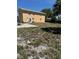 Backyard view of a home, featuring a patio and an unkept grassy yard at 8 E Summit St, Apopka, FL 32712