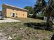 Exterior view of building showing the backyard and fence with patio and sparse grass. Person at door at 8 E Summit St, Apopka, FL 32712