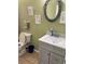 Bathroom with gray vanity, white sink, decorative mirror, and tiled floors at 8 E Summit St, Apopka, FL 32712
