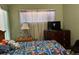 Bedroom featuring colorful Mario-themed bedding, natural light, and dark dresser at 8 E Summit St, Apopka, FL 32712