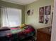 Bedroom showcasing youthful decor and wall art illuminated by natural light at 8 E Summit St, Apopka, FL 32712