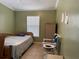 Bedroom features a bed, tiled floors, and window with blinds at 8 E Summit St, Apopka, FL 32712
