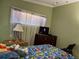 Bedroom featuring colorful Mario-themed bedding, natural light, and dark dresser at 8 E Summit St, Apopka, FL 32712