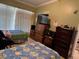 Bright bedroom with two twin beds, tile flooring, and a closet for storage at 8 E Summit St, Apopka, FL 32712