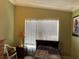 A simple bedroom, naturally lit, featuring a single bed and small side table at 8 E Summit St, Apopka, FL 32712