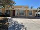 Charming home exterior with a red front door, decorative columns, and a well-manicured lawn at 8 E Summit St, Apopka, FL 32712