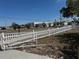 View of a fenced lot showing a white fence with gate. The area is partially paved with views of nearby buildings at 8 E Summit St, Apopka, FL 32712