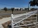 View of a fenced lot showing a white fence with gate. The area is partially paved with views of nearby buildings at 8 E Summit St, Apopka, FL 32712